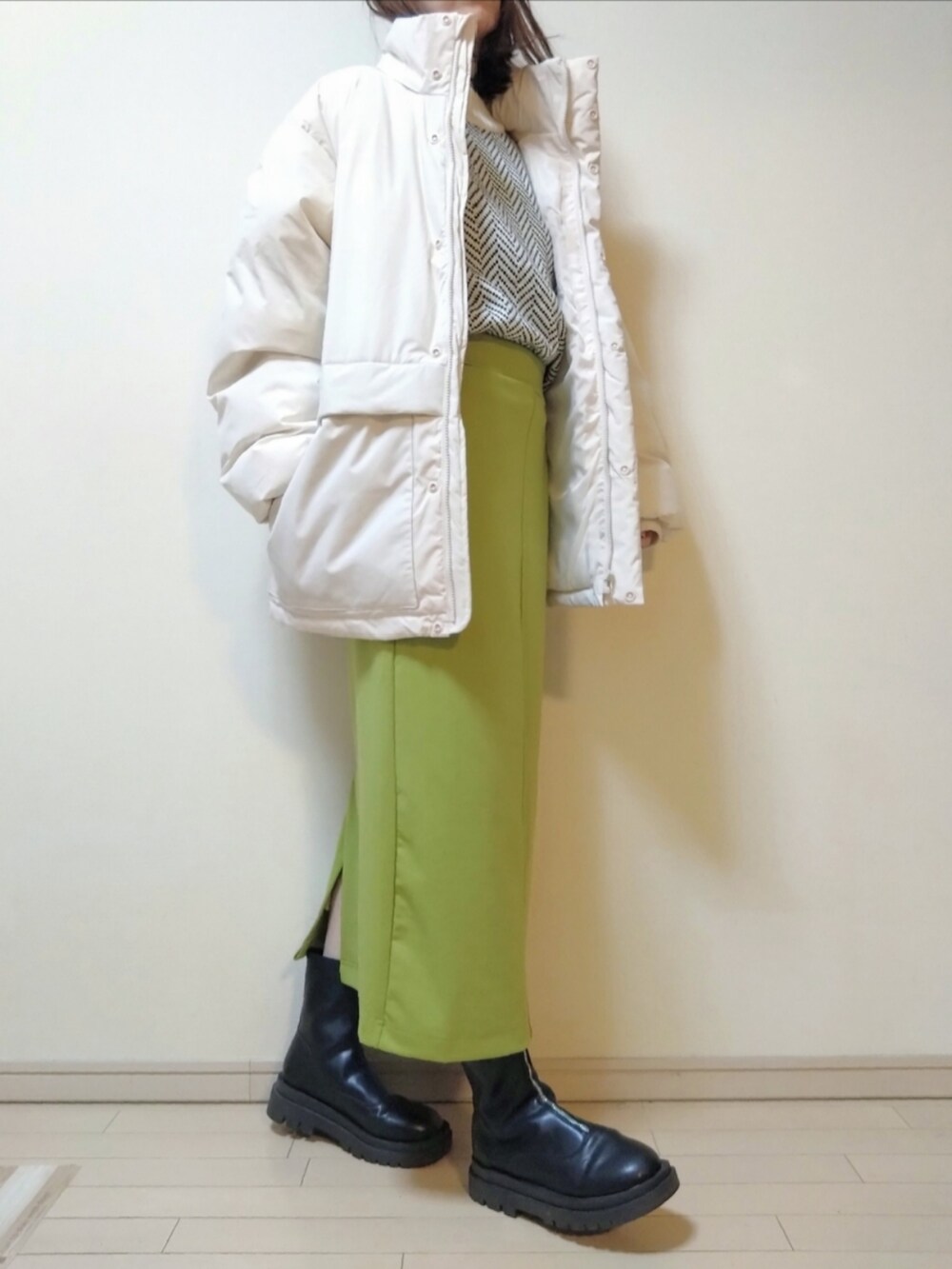 ホワイト系のダウンジャケット/コート、ホワイト系のニット/セーター、グリーン系のスカートを着用したレディースの冬コーディネートの2枚目の写真
