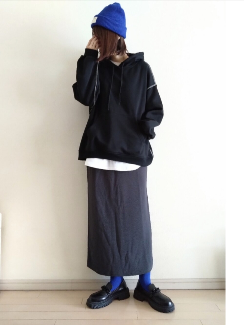 ブラック系のパーカー、ホワイト系のTシャツ/カットソー、グレー系のスカートを着用したレディースの冬コーディネートの2枚目の写真