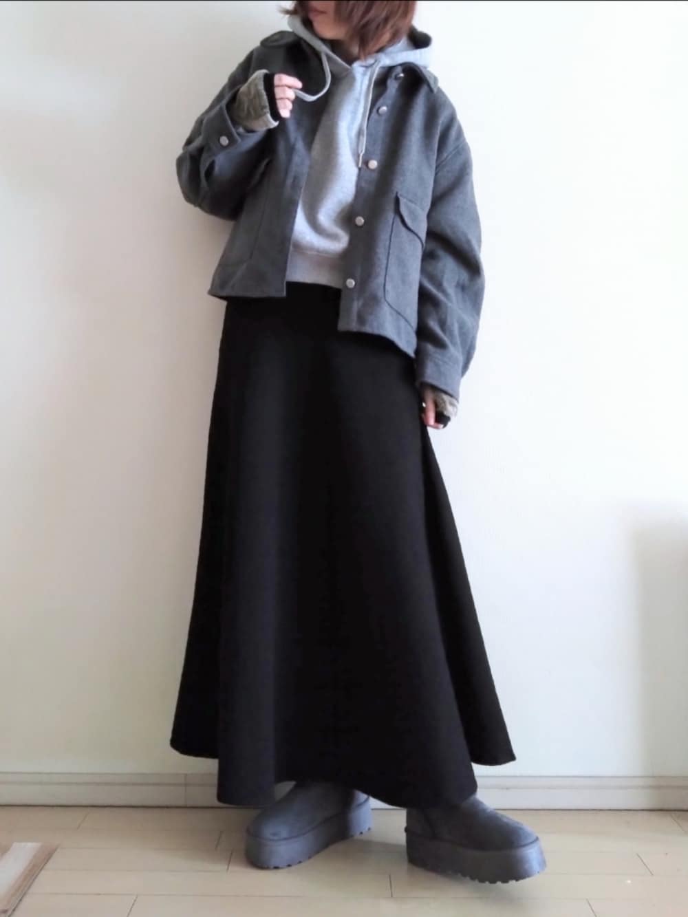 グレー系のその他アウター、グレー系のパーカー、ブラック系のスカートを着用したレディースの冬コーディネートの2枚目の写真