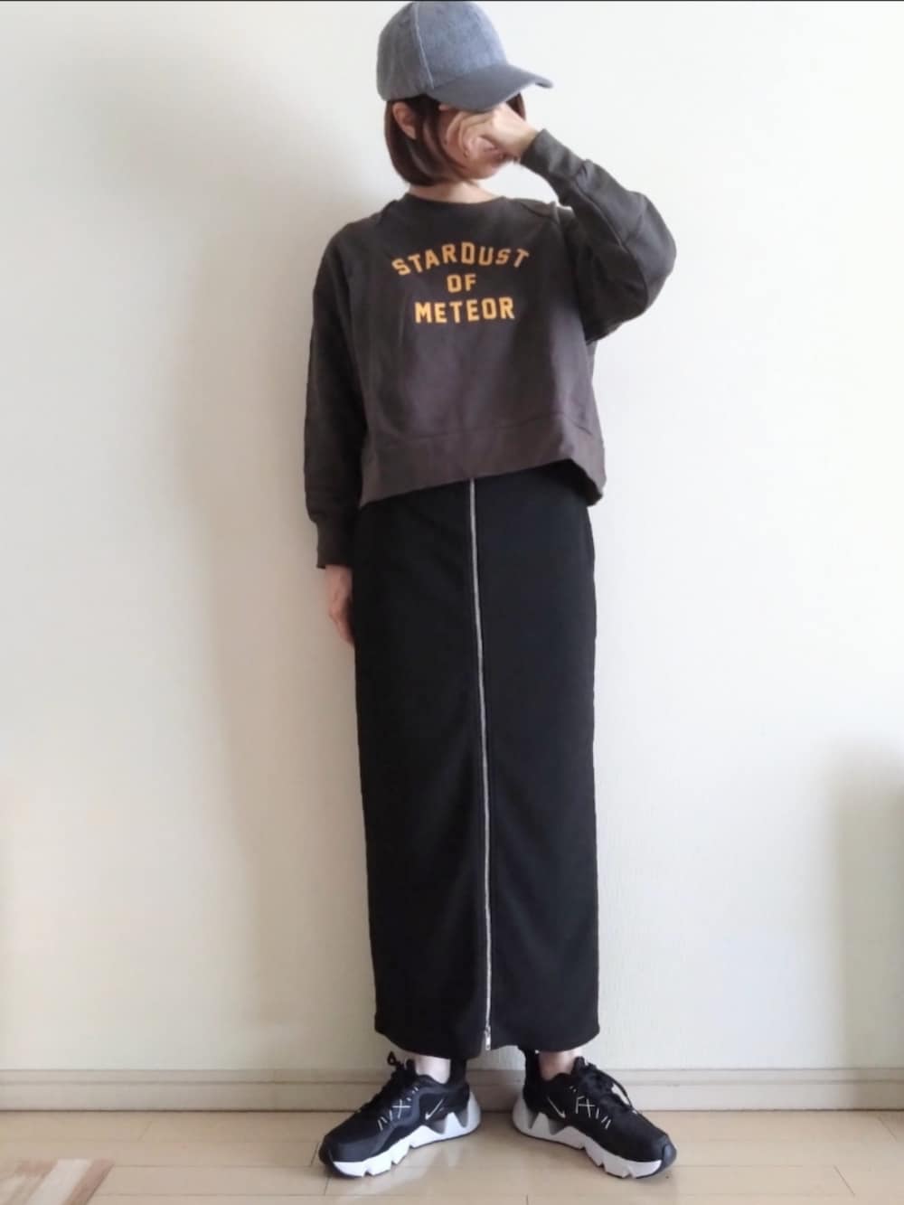 ブラック系のスウェット、ブラック系のスカート、ブラック系のスニーカーを着用したレディースの秋コーディネートの2枚目の写真