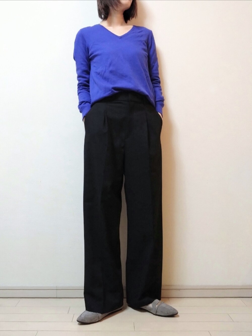 ブラック系のチェスターコート、ブルー系のニット/セーター、ブラック系のスラックスを着用したレディースの秋コーディネートの3枚目の写真