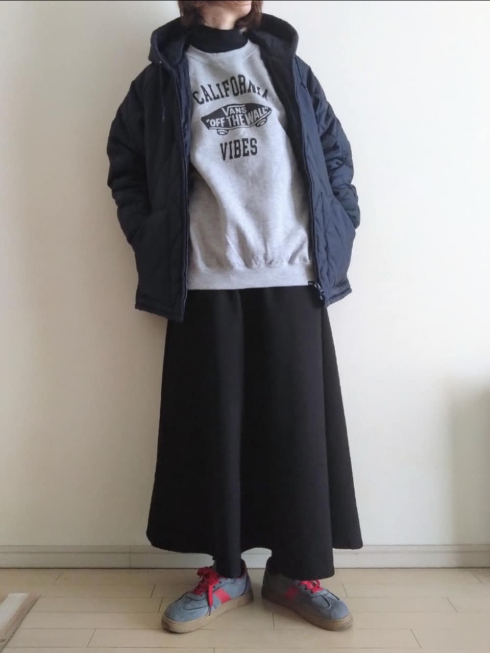 ブルー系のブルゾン、グレー系のスウェット、ブラック系のスカートを着用したレディースの冬コーディネートの2枚目の写真