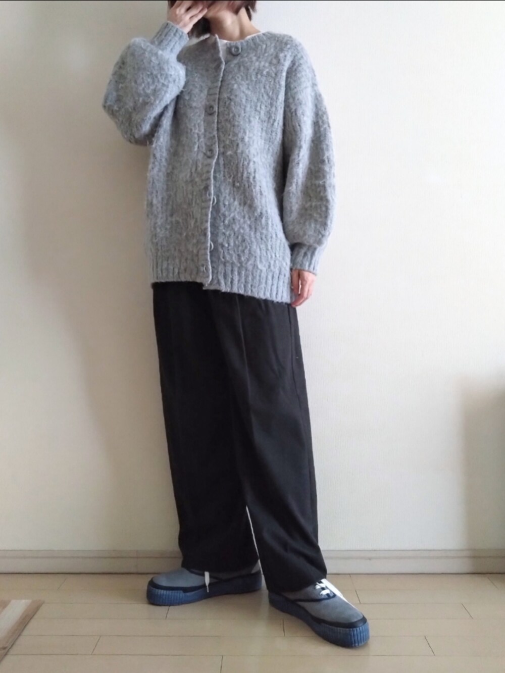グレー系のカーディガン/ボレロ、グレー系のスラックス、ブルー系のスニーカーを着用したレディースの秋コーディネートの2枚目の写真