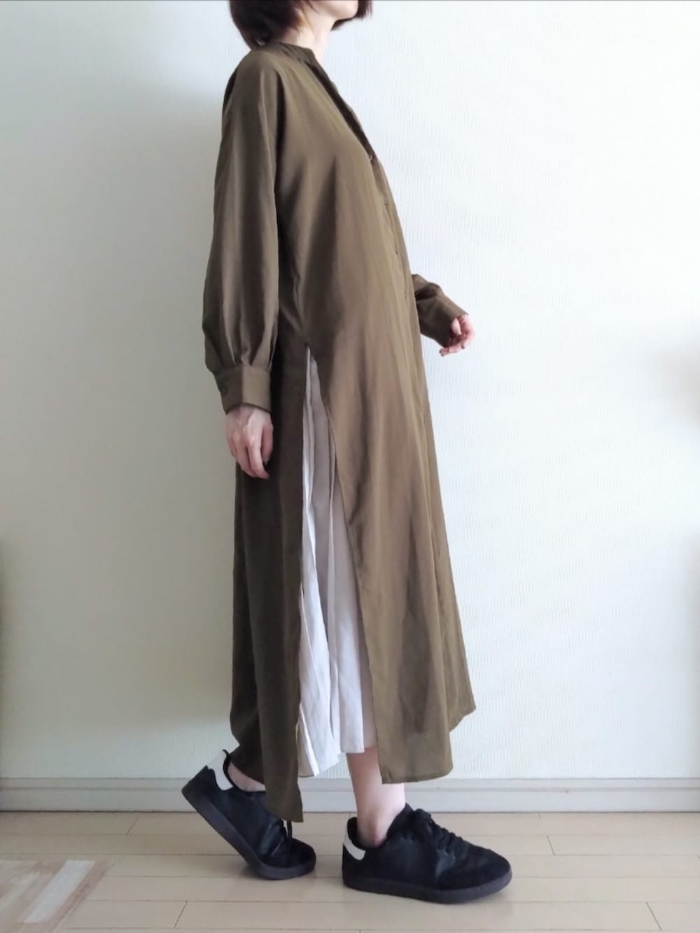 グリーン系のシャツワンピース、グレー系のワンピース、ブラック系のスニーカーを着用したレディースの春コーディネートの2枚目の写真