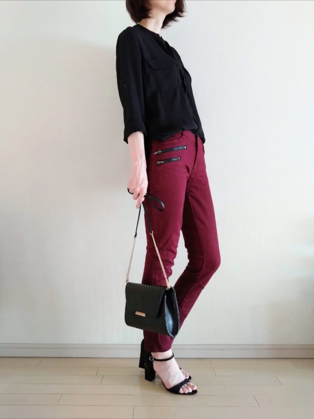 レッド系のデニムパンツ、ブラック系のシャツ/ブラウス、ブラック系のショルダーバッグを着用したレディースの秋コーディネートの2枚目の写真