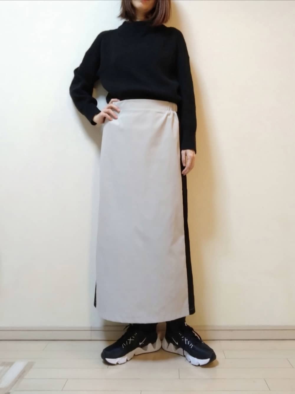 グリーン系のMA-1、ブラック系のニット/セーター、ベージュ系のスカートを着用したレディースの冬コーディネートの2枚目の写真