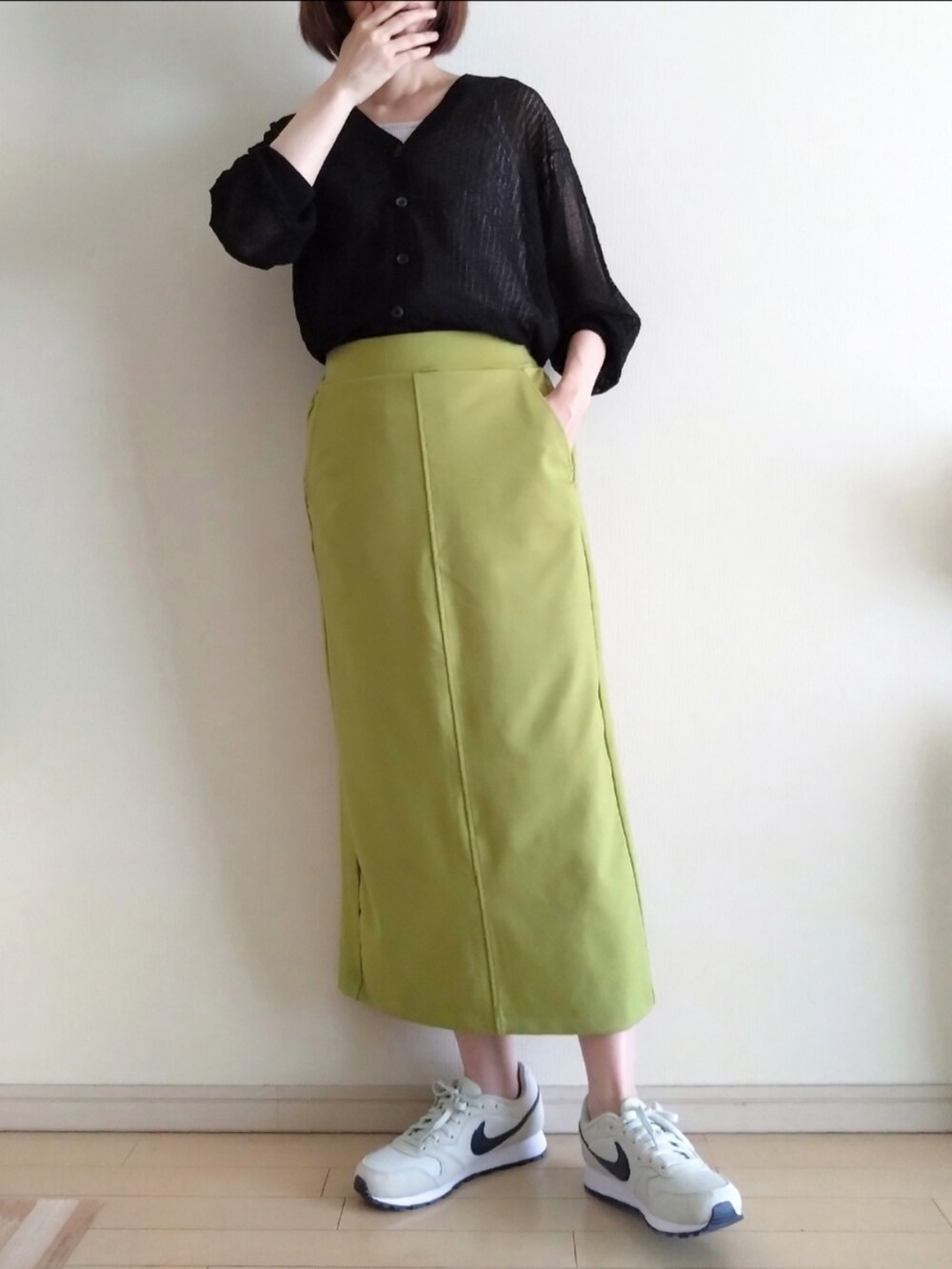 ブラック系のカーディガン/ボレロ、ベージュ系のタンクトップ、グリーン系のスカートを着用したレディースの夏コーディネートの2枚目の写真