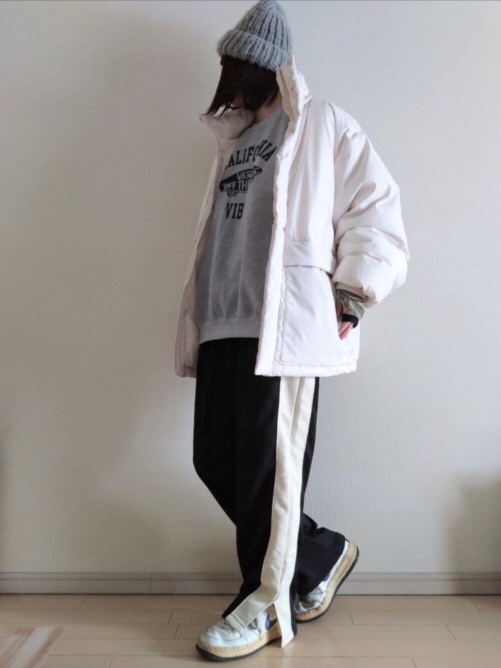 グレー系のスウェット、ホワイト系のダウンジャケット/コート、ブラック系のスウェットパンツを着用したレディースの冬コーディネートの2枚目の写真