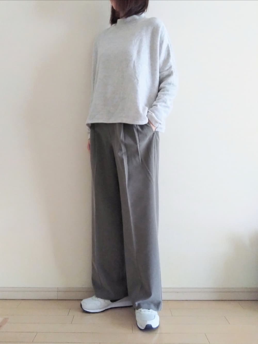 ホワイト系のダウンジャケット/コート、グレー系のニット/セーター、ブラウン系のスラックスを着用したレディースの冬コーディネートの4枚目の写真