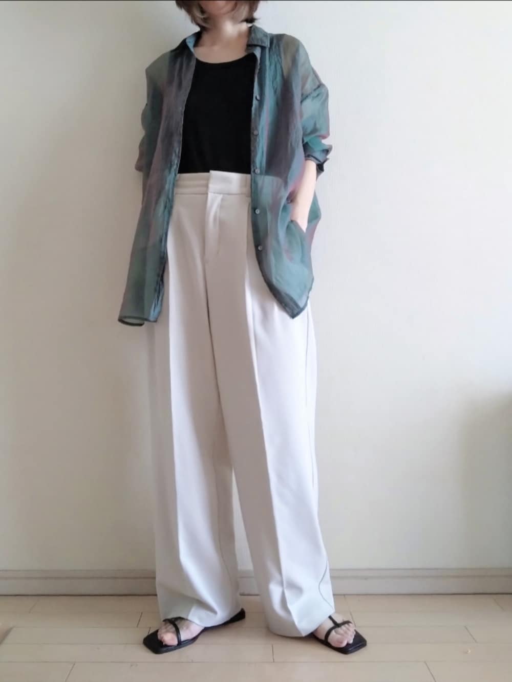 グリーン系のシャツ/ブラウス、ブラック系のタンクトップ、ホワイト系のスラックスを着用したレディースの夏コーディネートの2枚目の写真