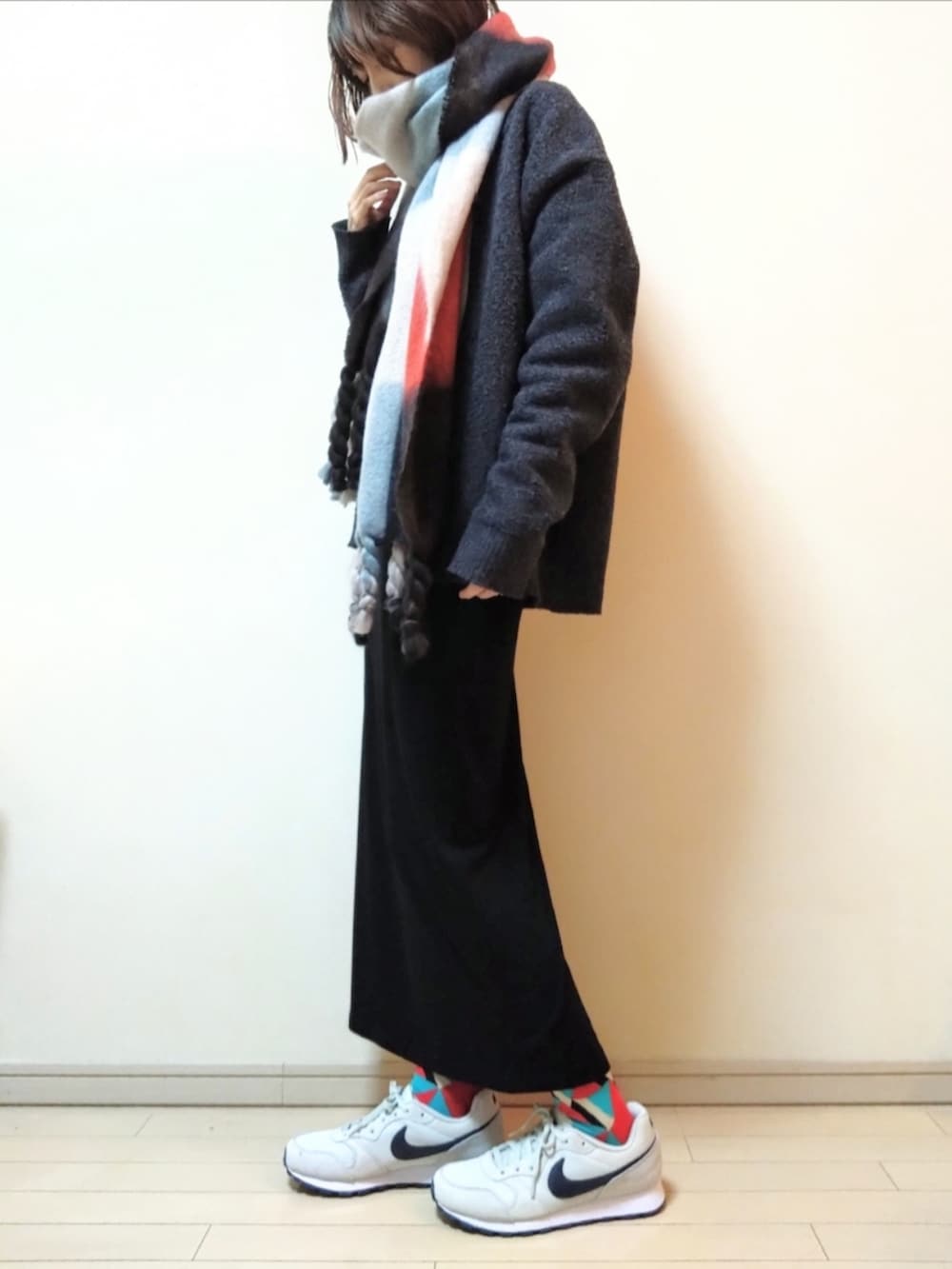 グレー系のカーディガン/ボレロ、グレー系のニット/セーター、ブラック系のスカートを着用したレディースの冬コーディネートの2枚目の写真