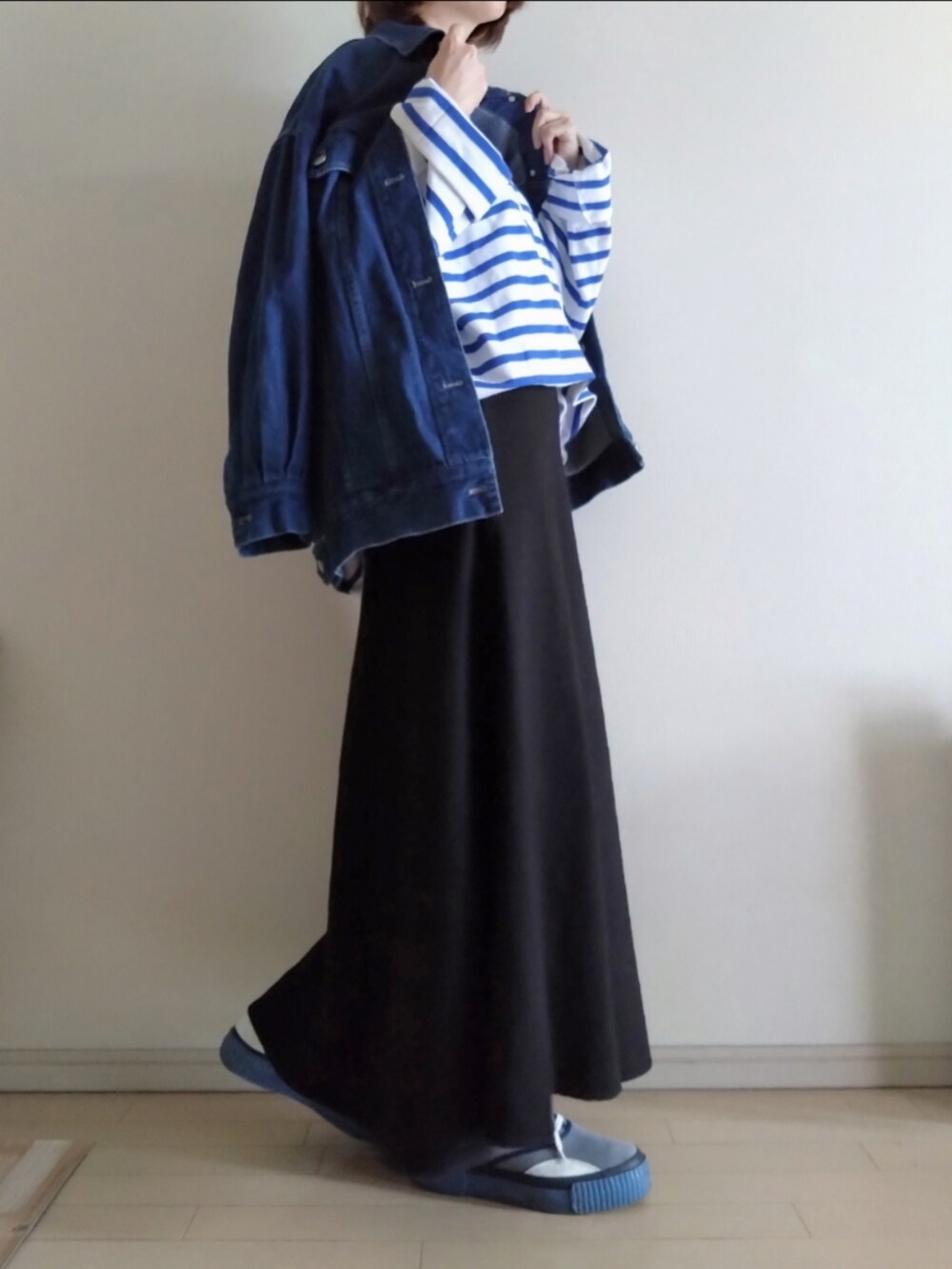 ブルー系のTシャツ/カットソー、ブルー系のデニムジャケット、ブラック系のスカートを着用したレディースの冬コーディネートの2枚目の写真