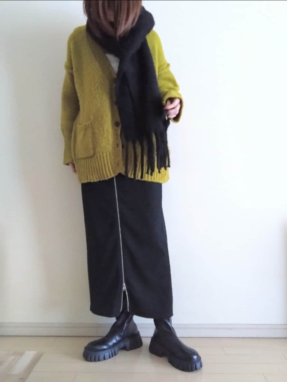 グリーン系のモッズコート、グリーン系のカーディガン/ボレロ、ブラック系のスカートを着用したレディースの冬コーディネートの3枚目の写真