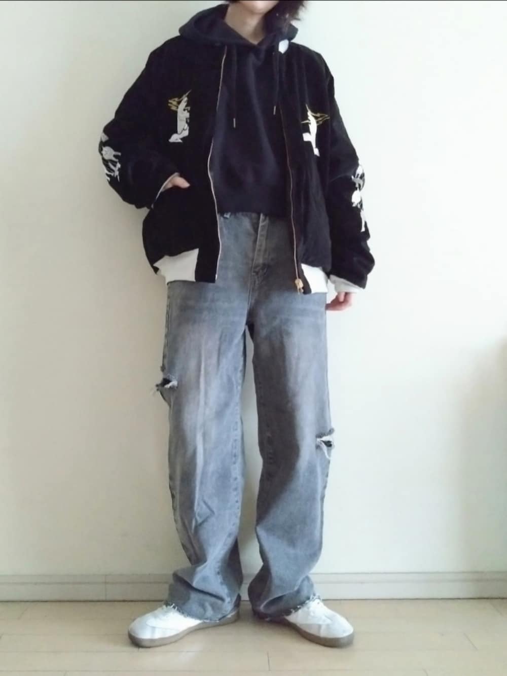 ブラック系のスカジャン、ブラック系のパーカー、グレー系のデニムパンツを着用したレディースの春コーディネートの3枚目の写真