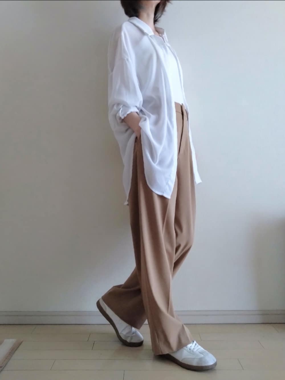 ホワイト系のシャツ/ブラウス、ホワイト系のキャミソール、ベージュ系のスラックスを着用したレディースの春コーディネートの2枚目の写真