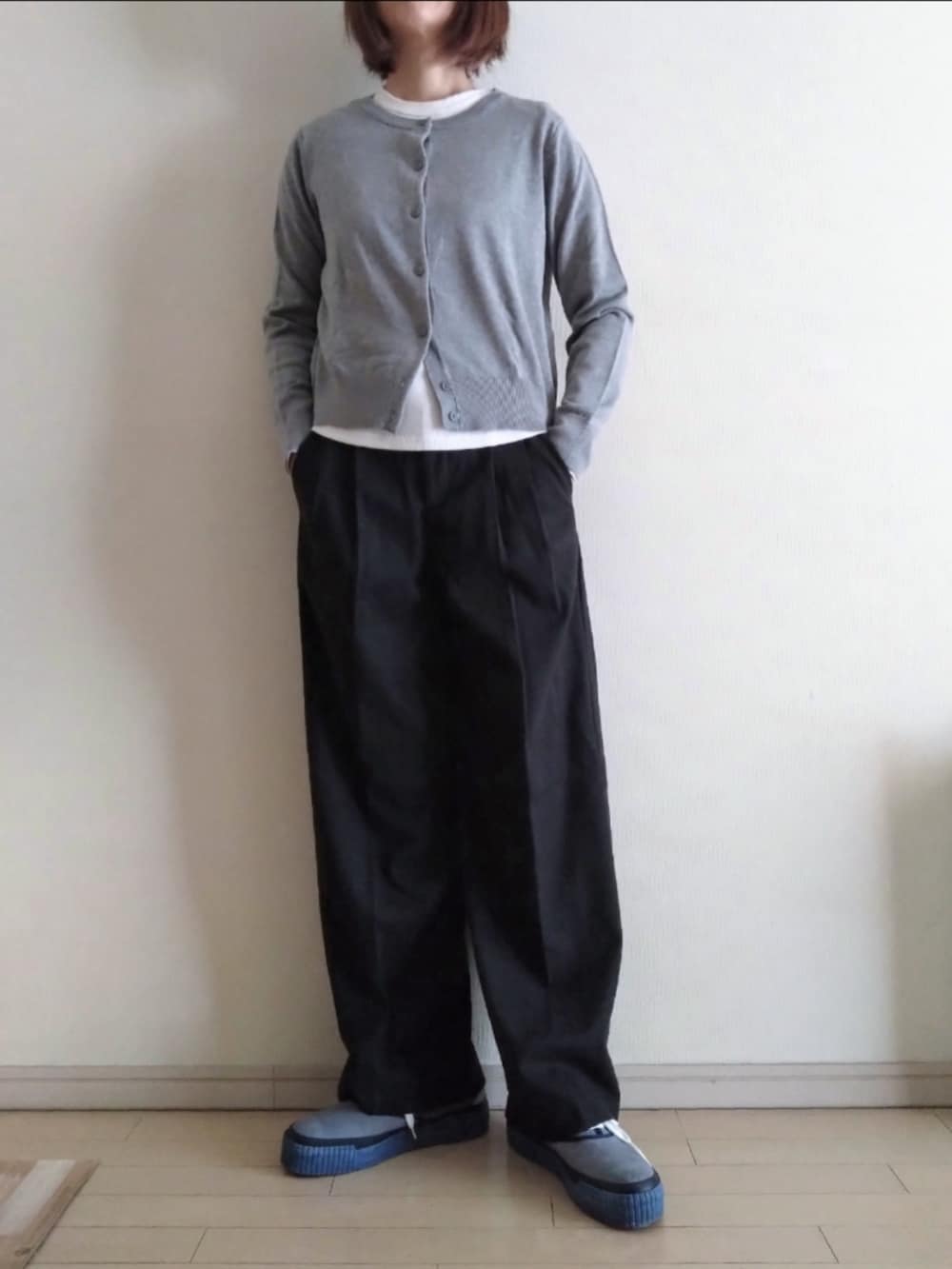 グレー系のトレンチコート、グレー系のカーディガン/ボレロ、グレー系のスラックスを着用したレディースの秋コーディネートの2枚目の写真