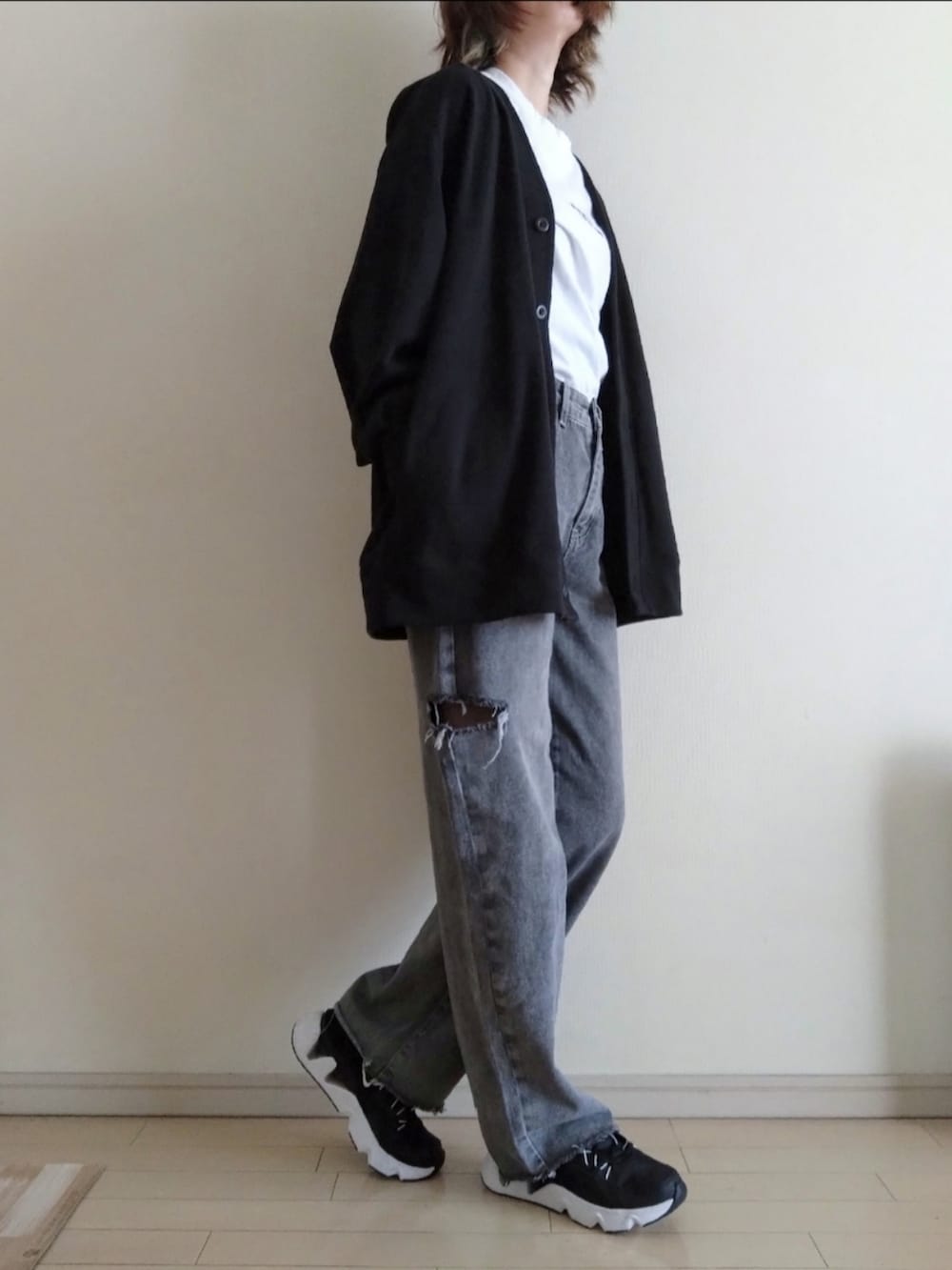 ブラック系のカーディガン/ボレロ、ホワイト系のTシャツ/カットソー、グレー系のデニムパンツを着用したレディースの秋コーディネートの2枚目の写真