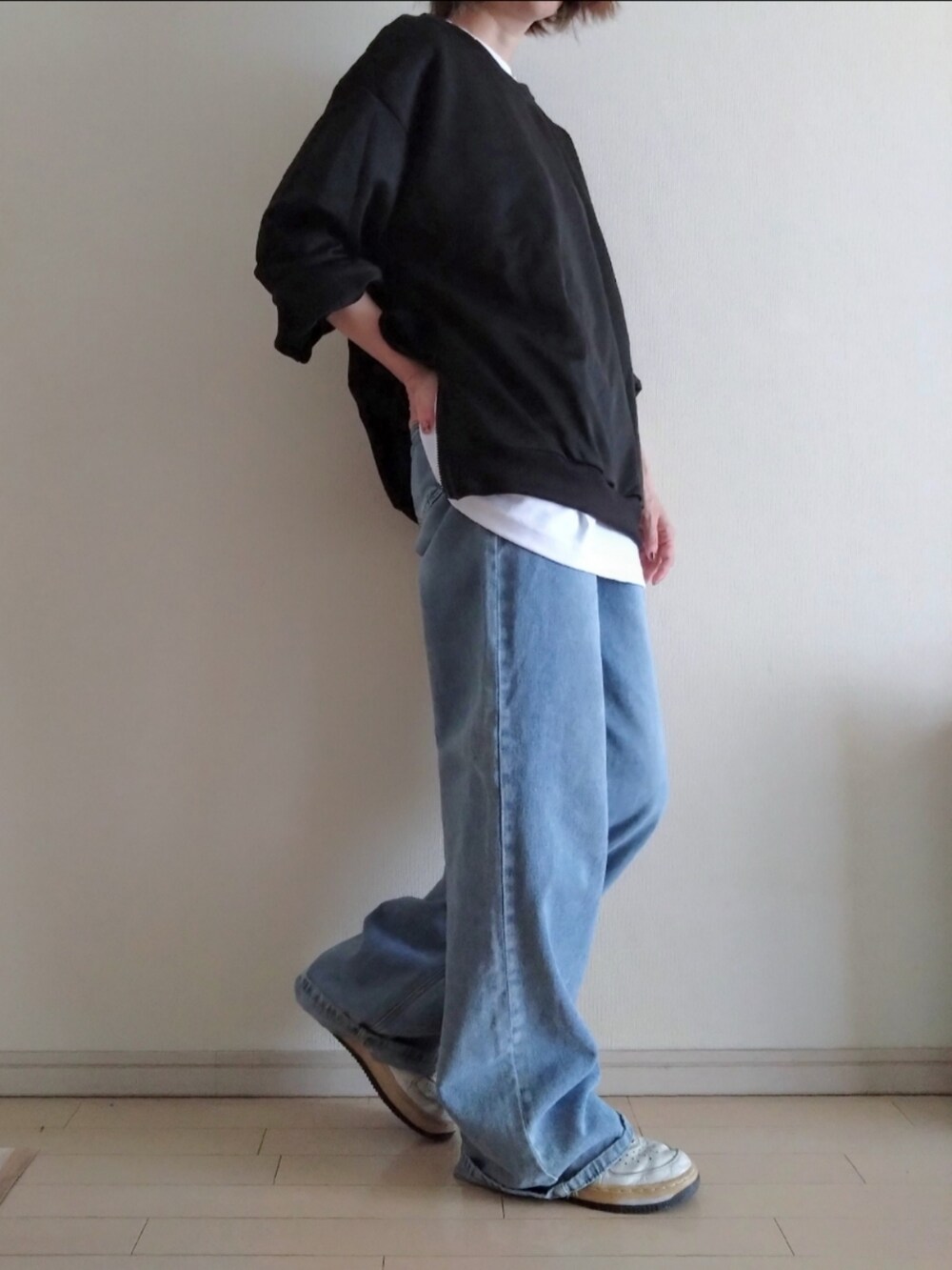 ブラック系のスウェット、ホワイト系のTシャツ/カットソー、ブルー系のデニムパンツを着用したレディースの秋コーディネートの2枚目の写真