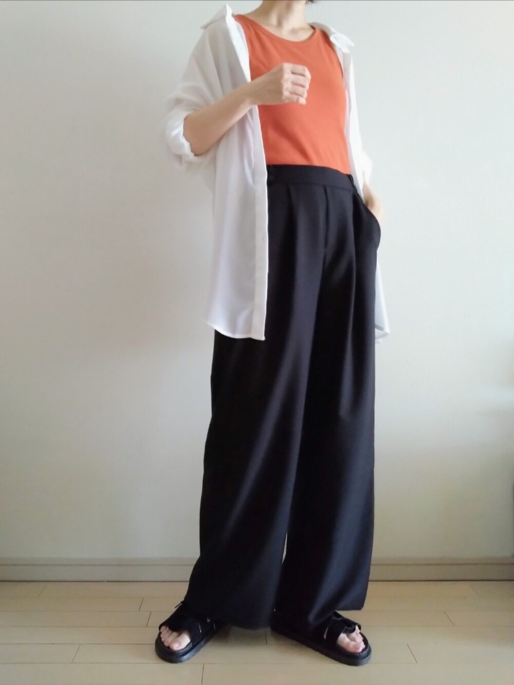 オレンジ系のタンクトップ、ホワイト系のシャツ/ブラウス、ブラック系のその他パンツを着用したレディースの夏コーディネートの2枚目の写真