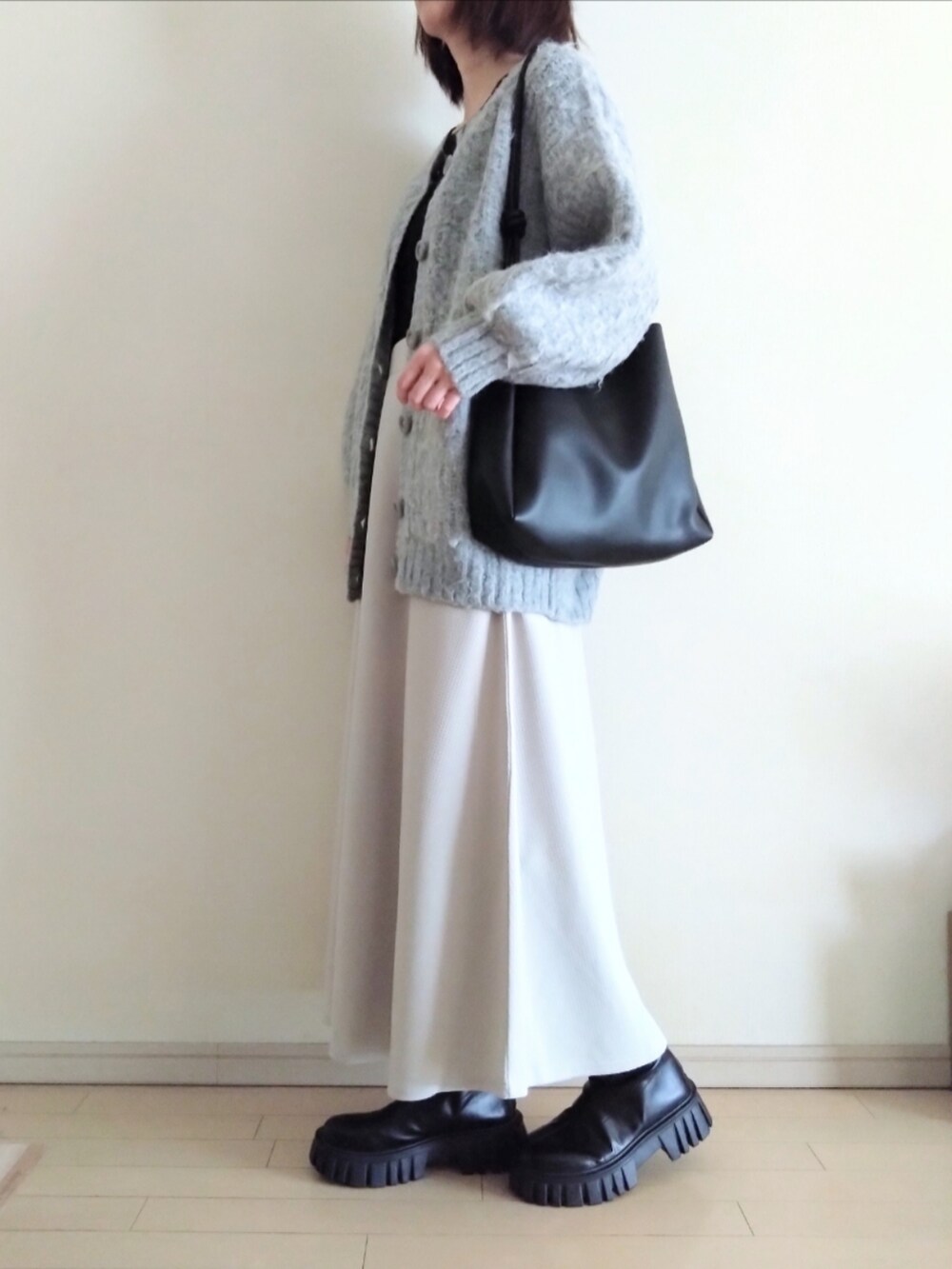 グレー系のカーディガン/ボレロ、ブラック系のTシャツ/カットソー、グレー系のスカートを着用したレディースの冬コーディネートの2枚目の写真