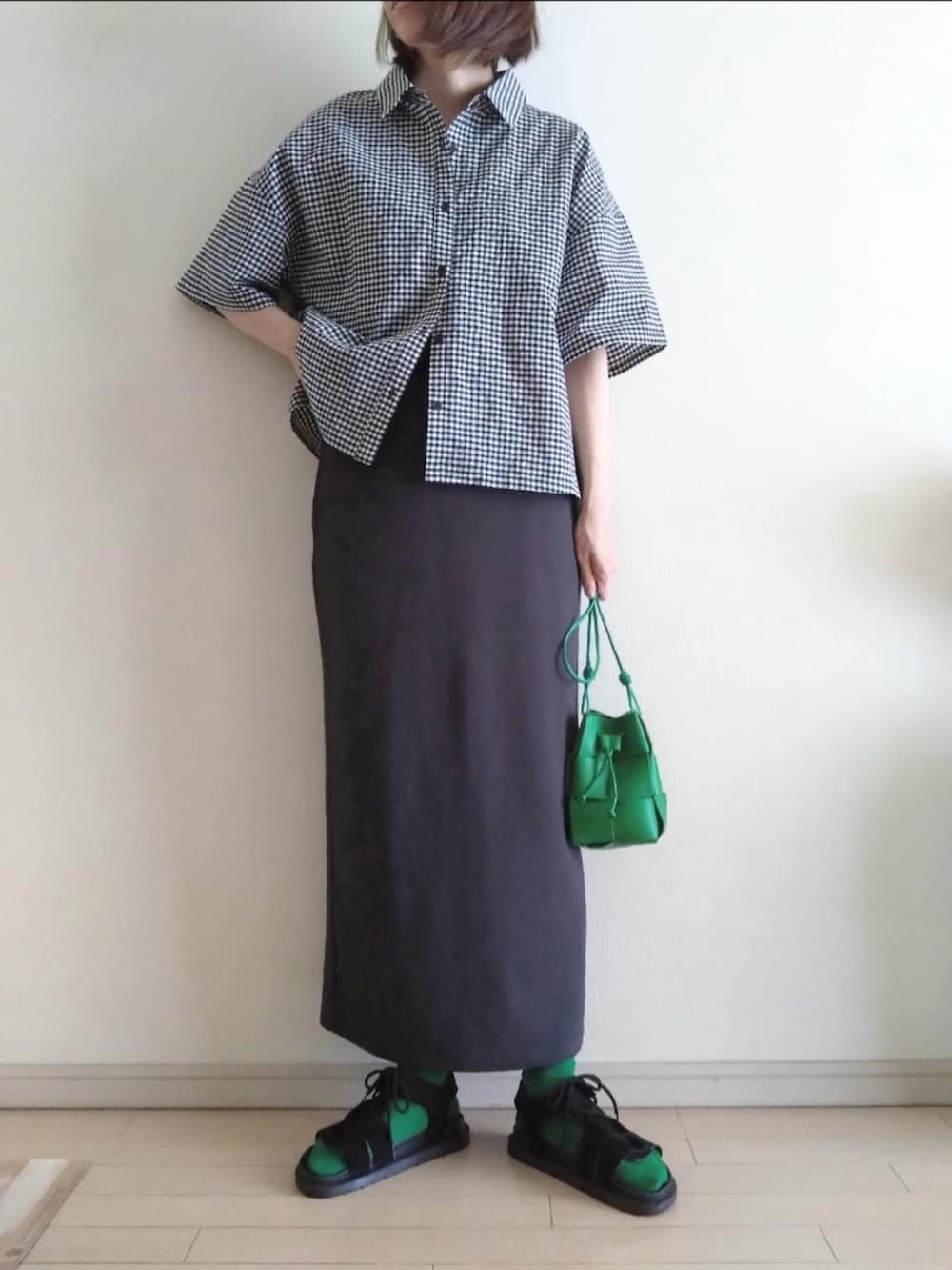 ホワイト系のシャツ/ブラウス、グレー系のスカート、グリーン系のショルダーバッグを着用したレディースの夏コーディネートの2枚目の写真