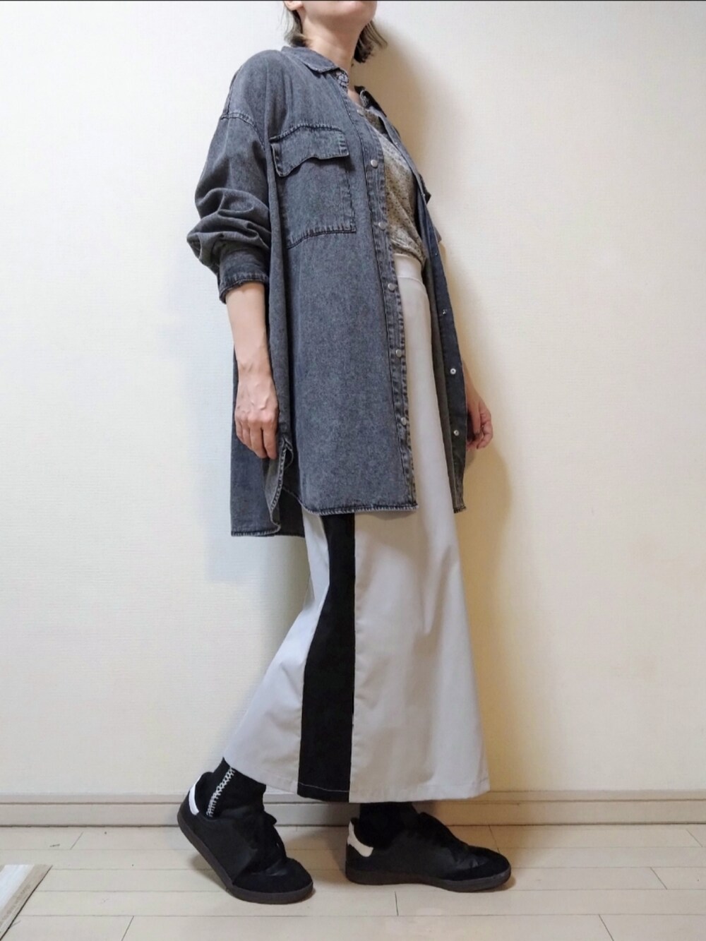 ブラック系のシャツ/ブラウス、グレー系のTシャツ/カットソー、ベージュ系のスカートを着用したレディースの秋コーディネートの2枚目の写真