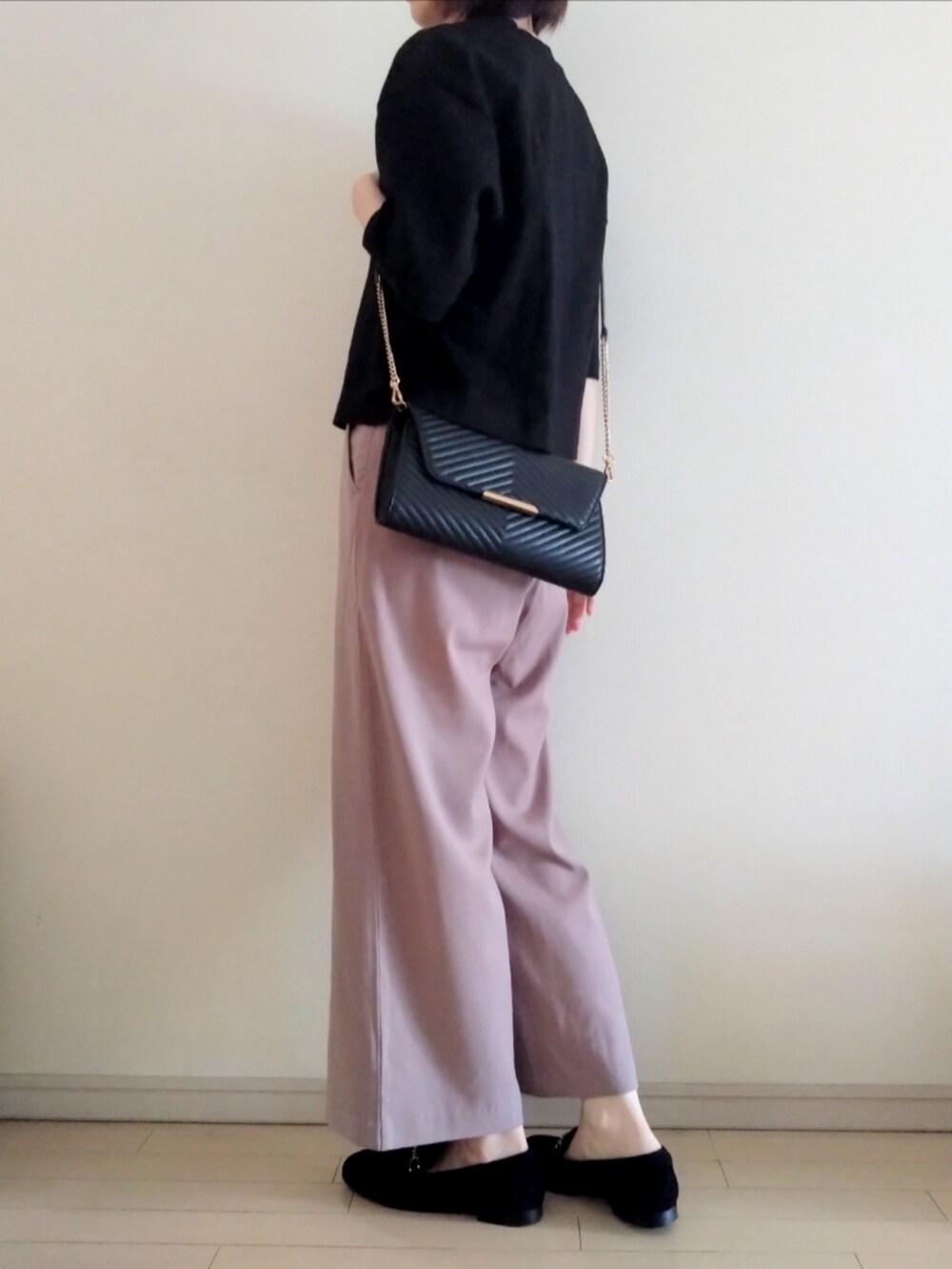 ブラック系のTシャツ/カットソー、グレー系のスラックス、ブラック系のショルダーバッグを着用したレディースの夏コーディネートの2枚目の写真