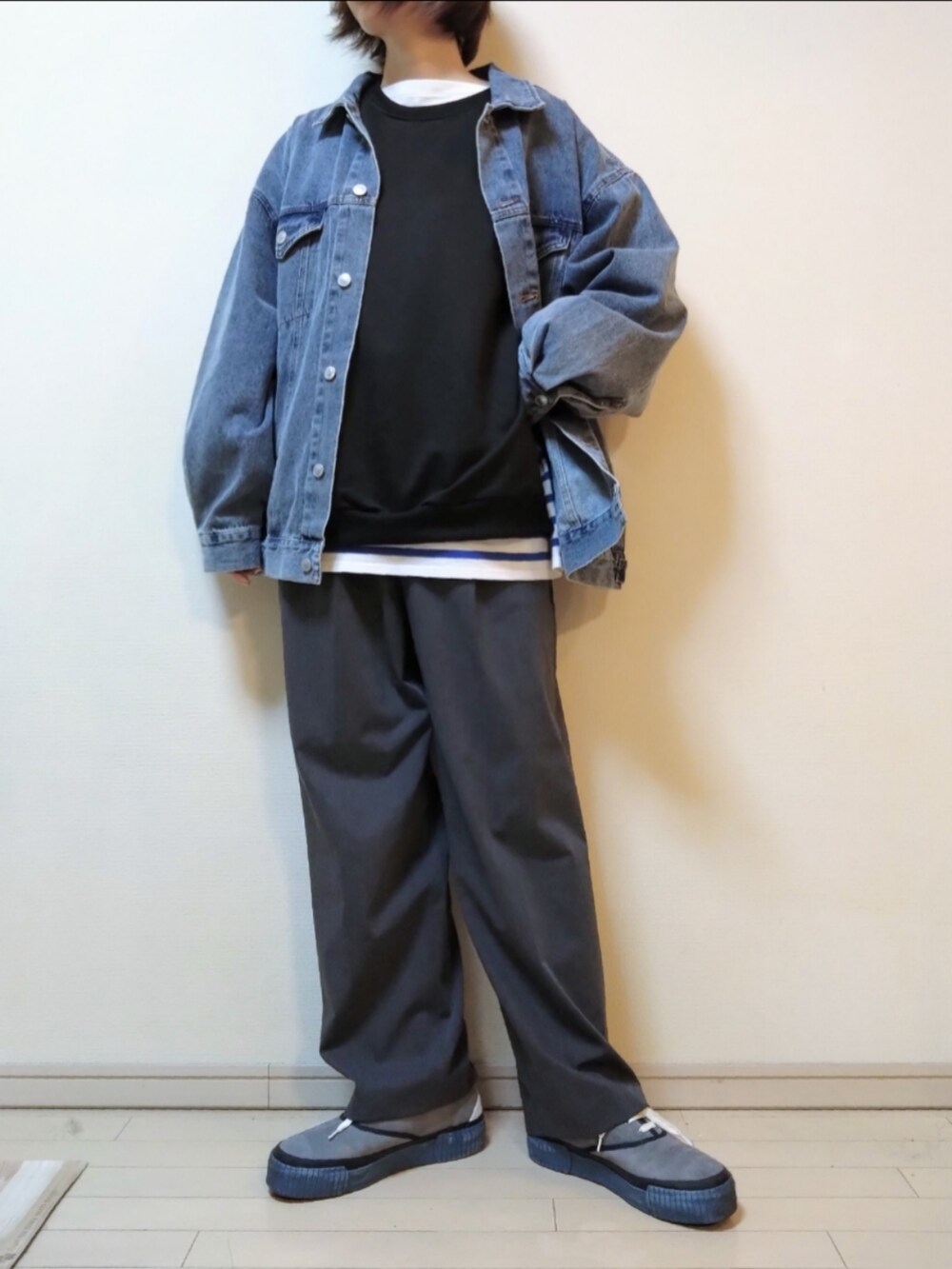 ブルー系のデニムジャケット、ブラック系のスウェット、ブルー系のTシャツ/カットソーを着用したレディースの春コーディネートの2枚目の写真