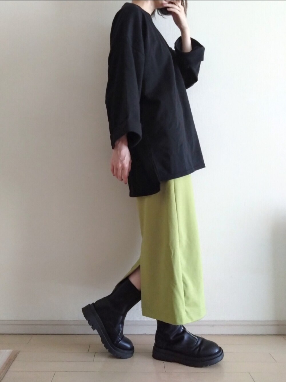 ブラック系のスウェット、グリーン系のスカート、ブラック系のブーツを着用したレディースの秋コーディネートの2枚目の写真