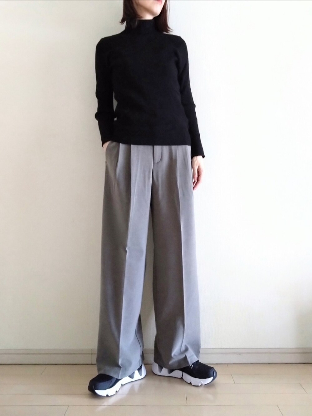 ブルー系のデニムジャケット、ブラック系のニット/セーター、ブラウン系のスラックスを着用したレディースの冬コーディネートの2枚目の写真