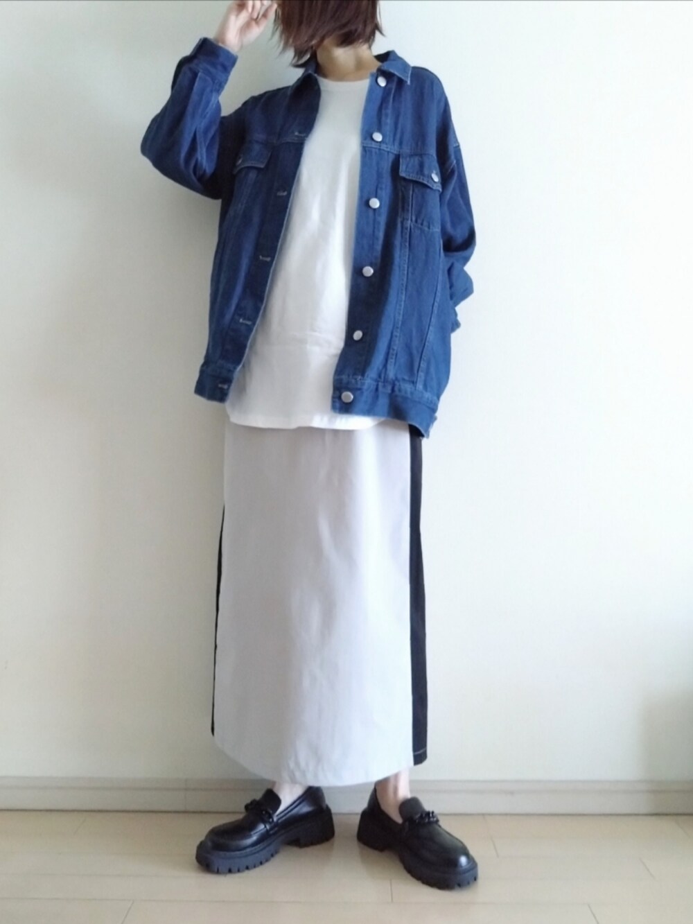 ブルー系のデニムジャケット、ホワイト系のTシャツ/カットソー、ベージュ系のスカートを着用したレディースの秋コーディネートの2枚目の写真