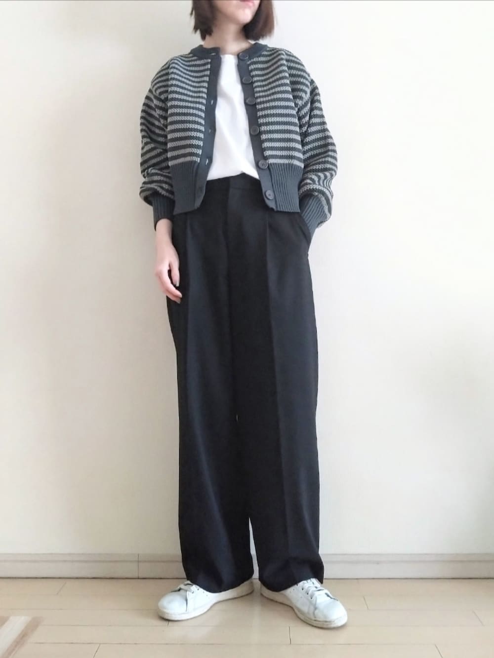 グレー系のカーディガン/ボレロ、ホワイト系のTシャツ/カットソー、ブラック系のスラックスを着用したレディースの春コーディネートの2枚目の写真