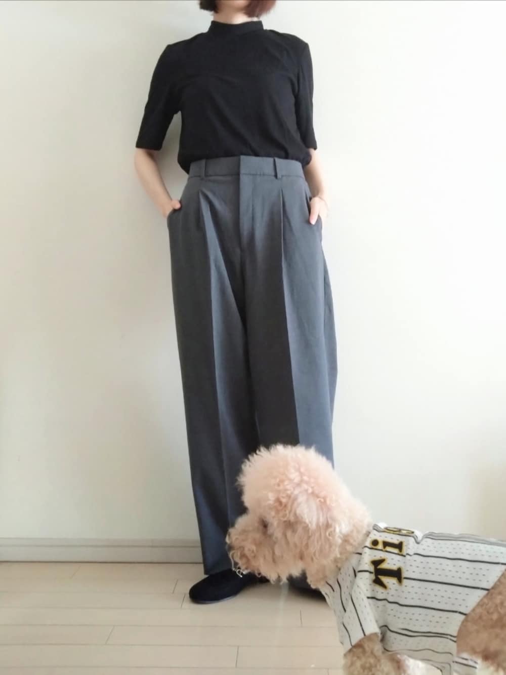 グレー系のスラックス、ブラック系のTシャツ/カットソー、ブラック系のローファーを着用したレディースの秋コーディネートの2枚目の写真