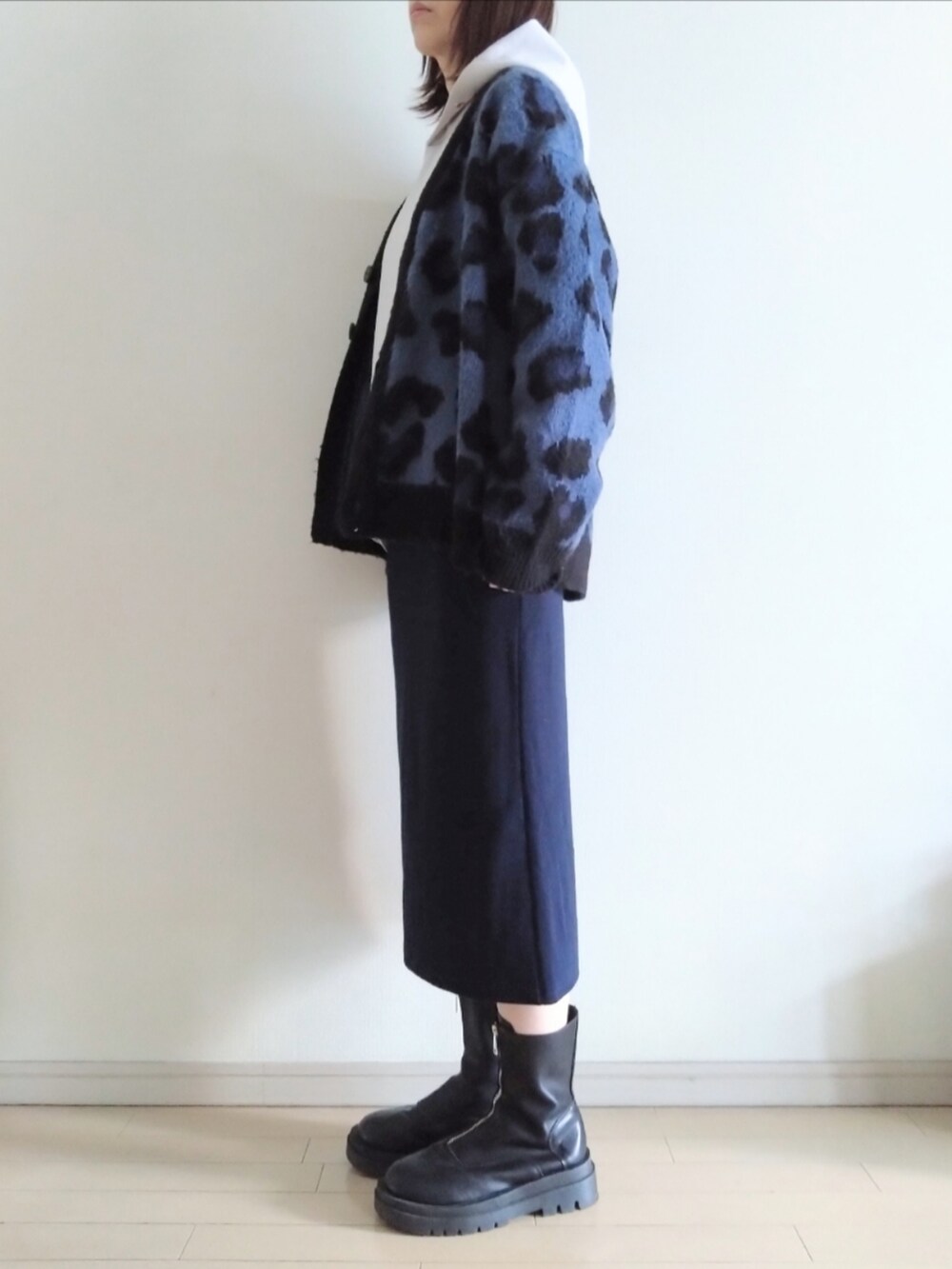 ブラック系のカーディガン/ボレロ、ベージュ系のパーカー、ブルー系のスカートを着用したレディースの冬コーディネートの2枚目の写真