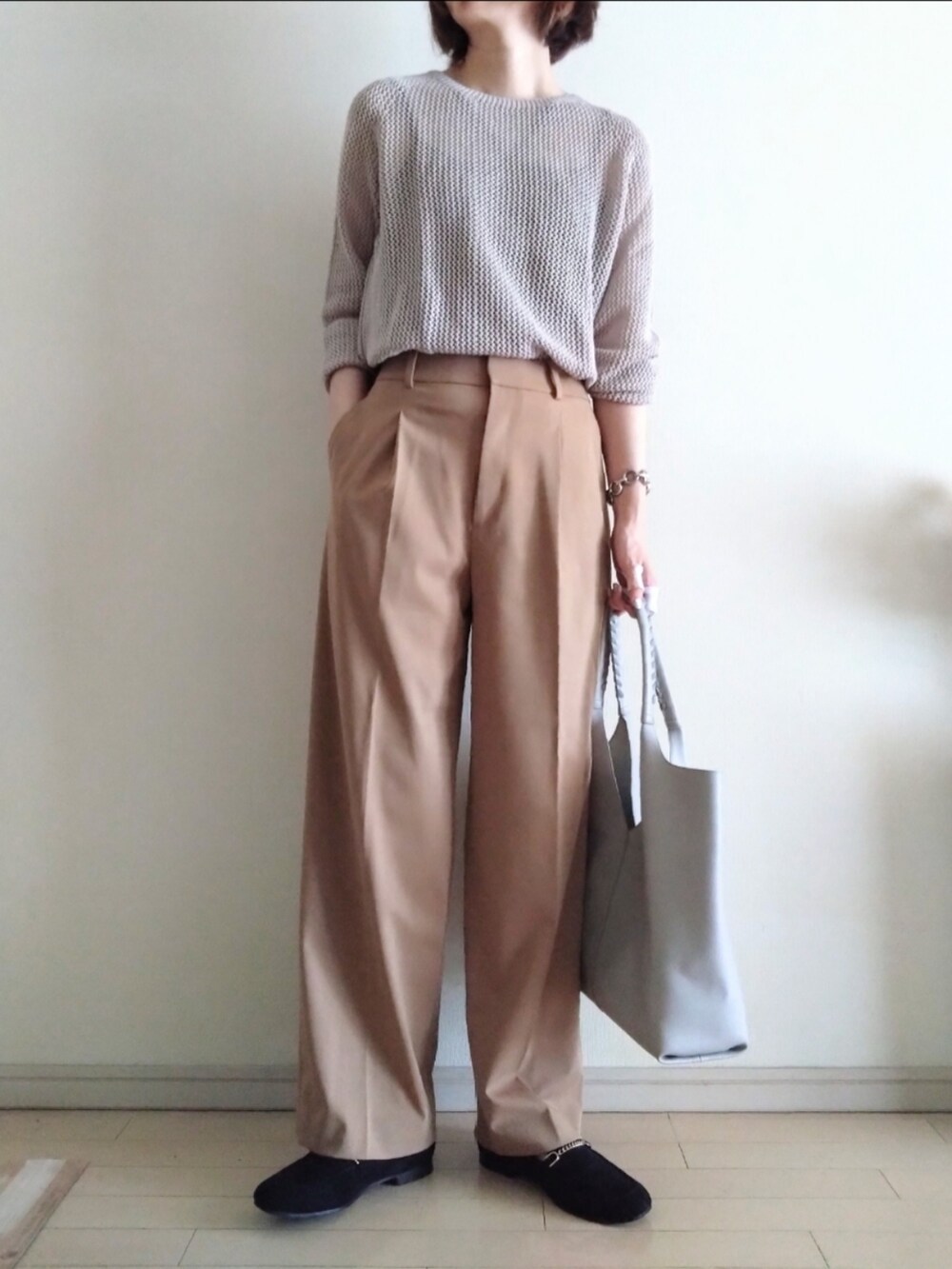 グレー系のニット/セーター、ブラック系のキャミソール、ベージュ系のスラックスを着用したレディースの夏コーディネートの2枚目の写真