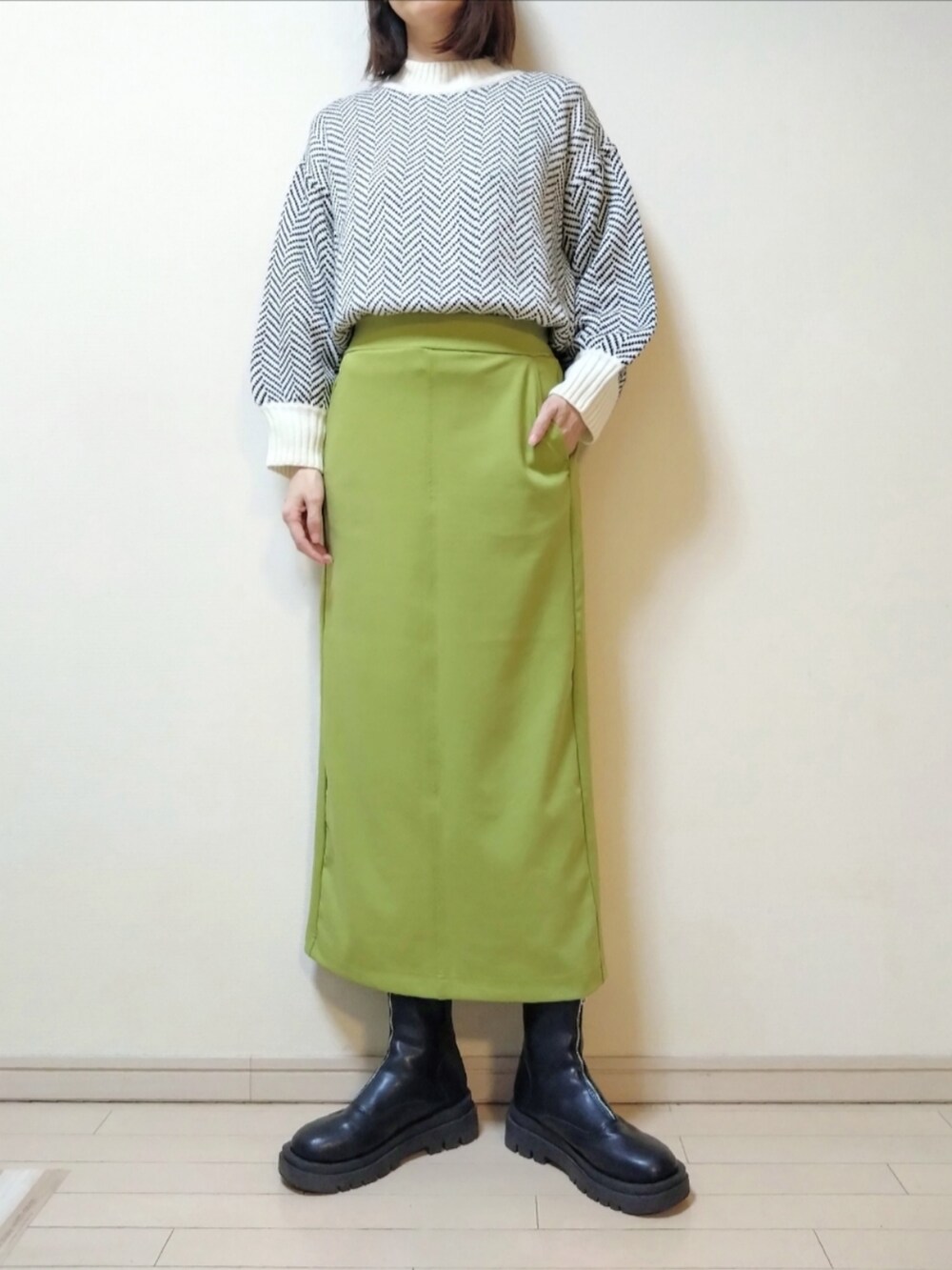 ホワイト系のダウンジャケット/コート、ホワイト系のニット/セーター、グリーン系のスカートを着用したレディースの冬コーディネートの3枚目の写真