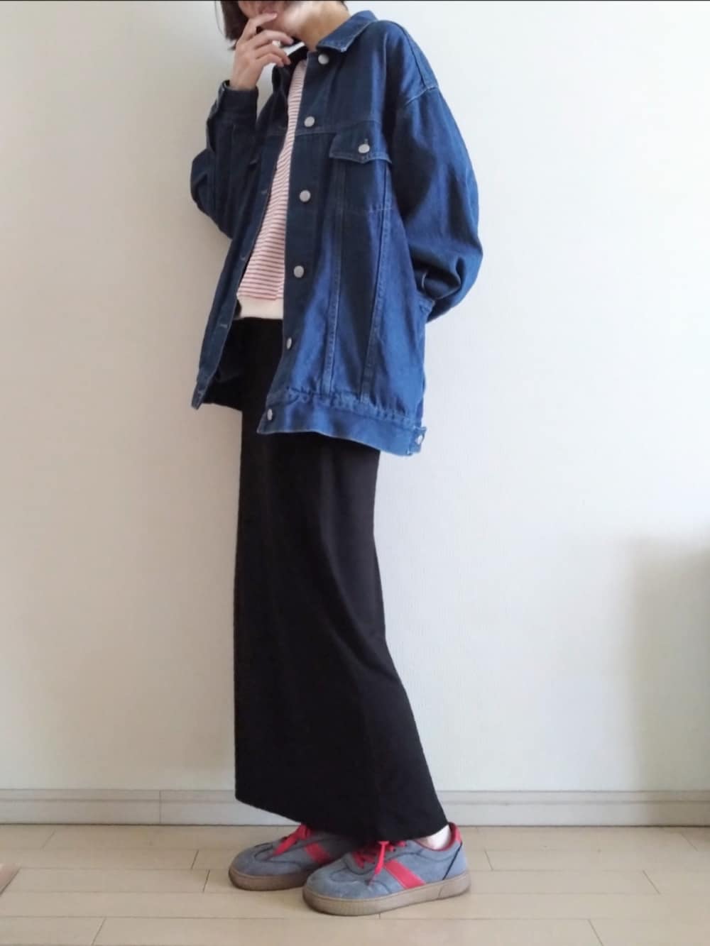 ブルー系のデニムジャケット、レッド系のスウェット、ブラック系のスカートを着用したレディースの春コーディネートの2枚目の写真