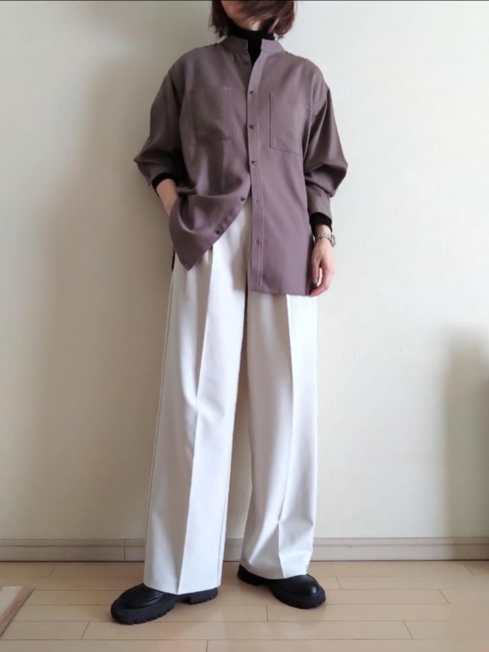 ブラック系のチェスターコート、ブラック系のTシャツ/カットソー、パープル系のシャツ/ブラウスを着用したレディースの冬コーディネートの2枚目の写真