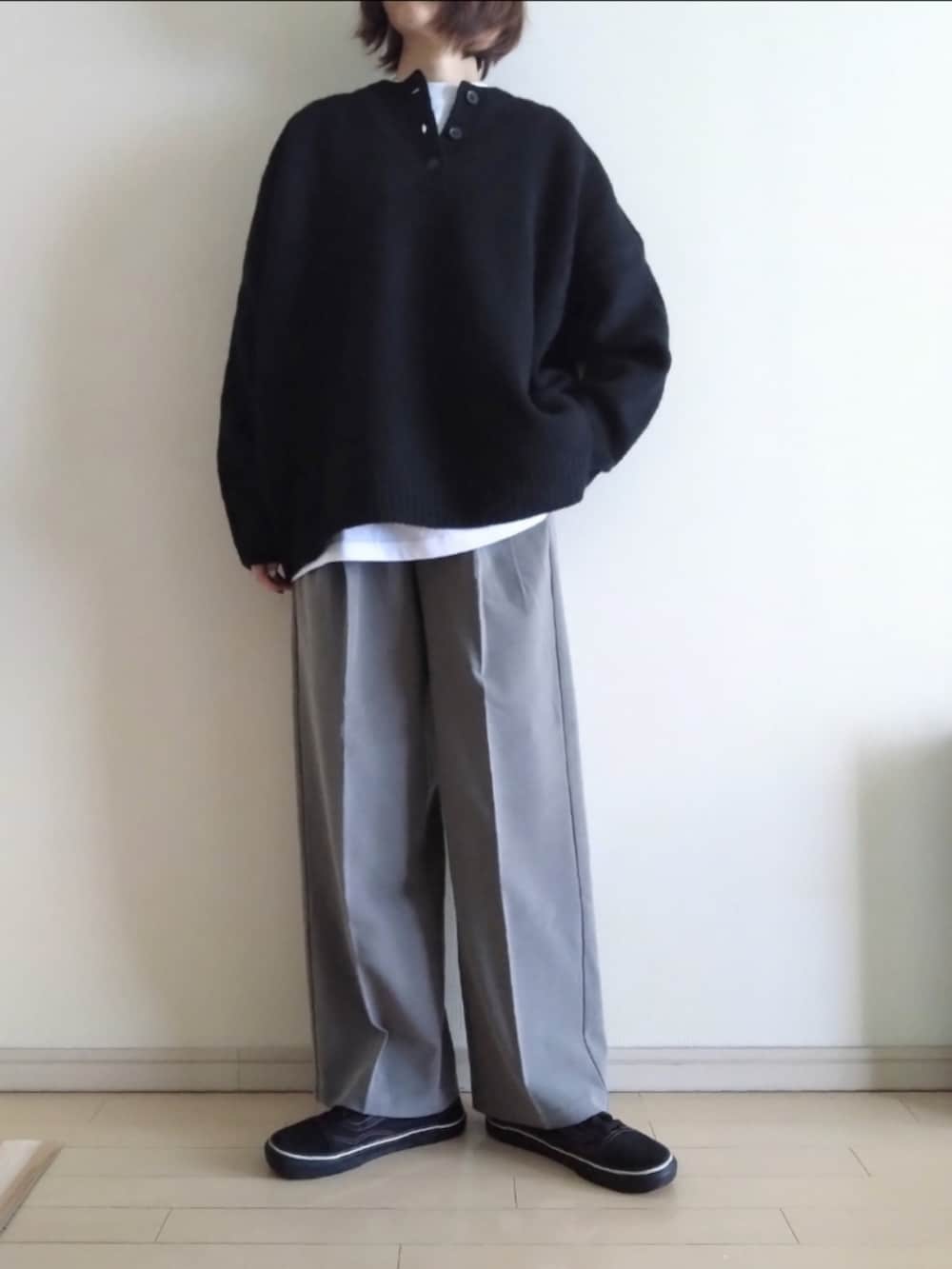 ブラック系のニット/セーター、ホワイト系のTシャツ/カットソー、ブラウン系のスラックスを着用したレディースの冬コーディネートの2枚目の写真