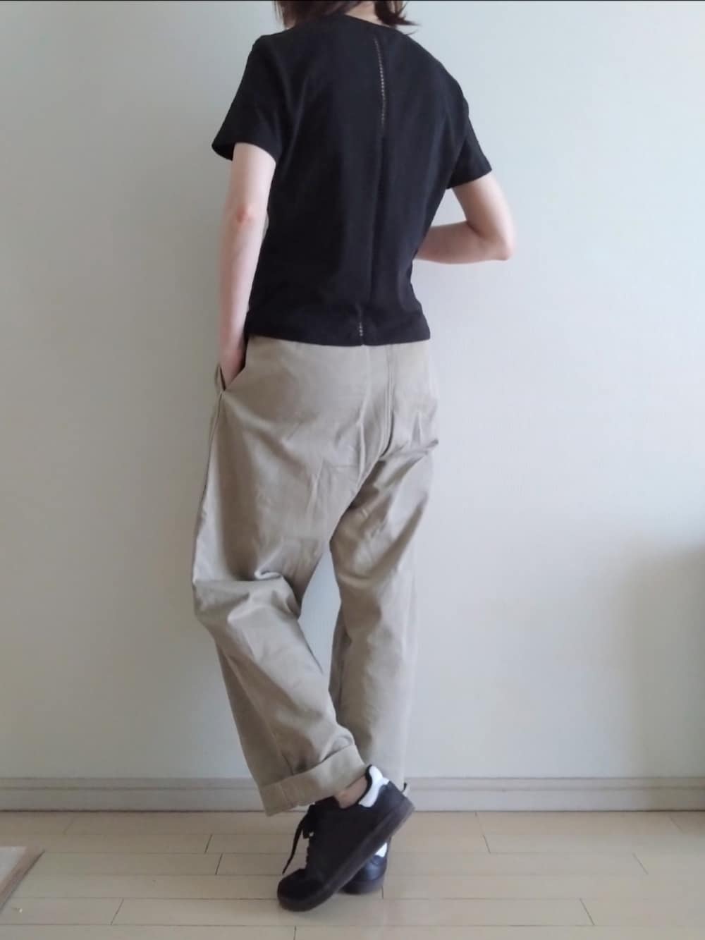 ブラック系のTシャツ/カットソー、ベージュ系のチノパンツ、ブラック系のスニーカーを着用したレディースの夏コーディネートの2枚目の写真