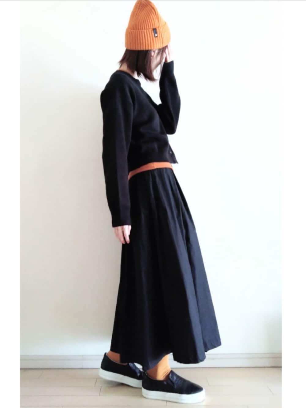 ブラック系のカーディガン/ボレロ、ブラウン系のTシャツ/カットソー、ブラック系のスカートを着用したレディースの冬コーディネートの2枚目の写真