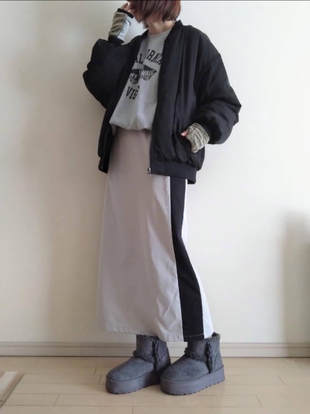 ブラック系のブルゾン、グレー系のスウェット、ベージュ系のスカートを着用したレディースの冬コーディネートの2枚目の写真