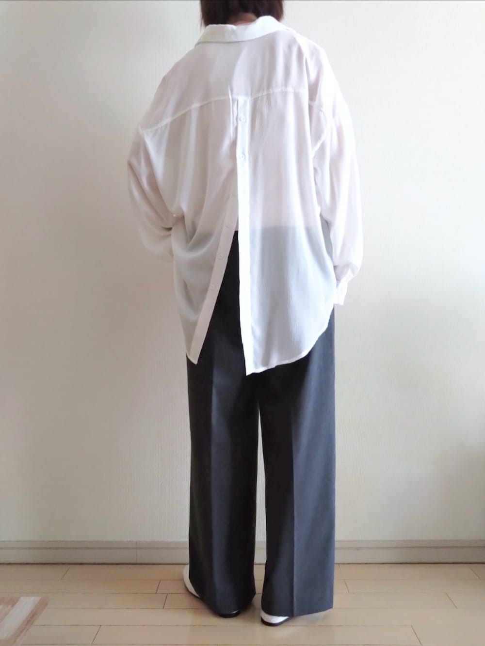 ピンク系のTシャツ/カットソー、ホワイト系のシャツ/ブラウス、グレー系のスラックスを着用したレディースの春コーディネートの2枚目の写真