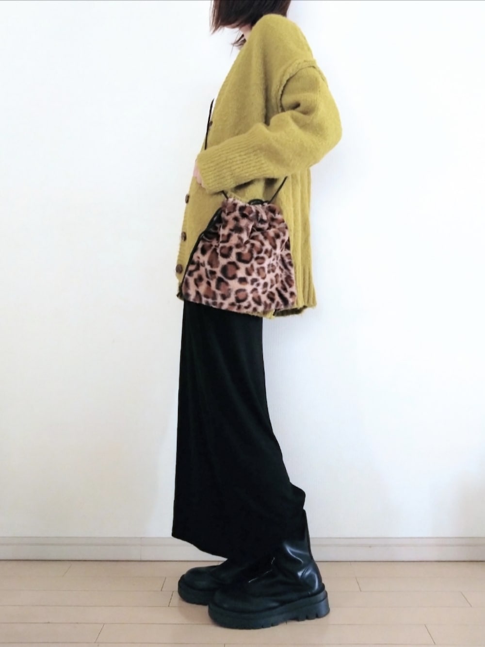 グリーン系のカーディガン/ボレロ、ホワイト系のTシャツ/カットソー、ブラウン系のショルダーバッグを着用したレディースの秋コーディネートの2枚目の写真