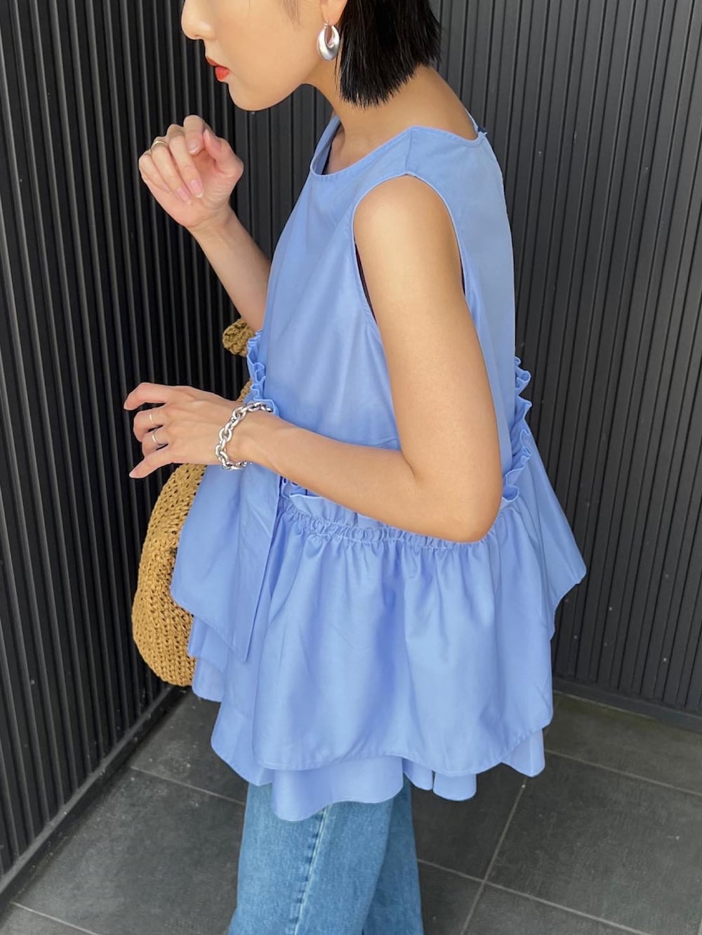 ブルー系のシャツ/ブラウス、ベージュ系のかごバッグ、ブラック系のサンダルを着用したレディースの春コーディネートの4枚目の写真