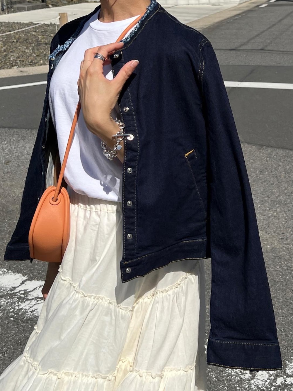 ブルー系のデニムジャケット、ホワイト系のTシャツ/カットソー、ホワイト系のスカートを着用したレディースの春コーディネートの4枚目の写真