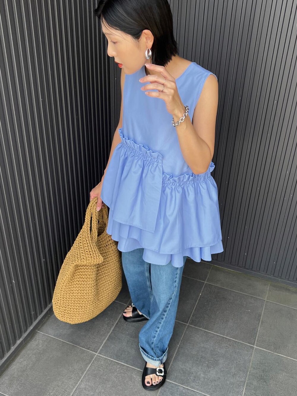 ブルー系のシャツ/ブラウス、ベージュ系のかごバッグ、ブラック系のサンダルを着用したレディースの春コーディネートの3枚目の写真