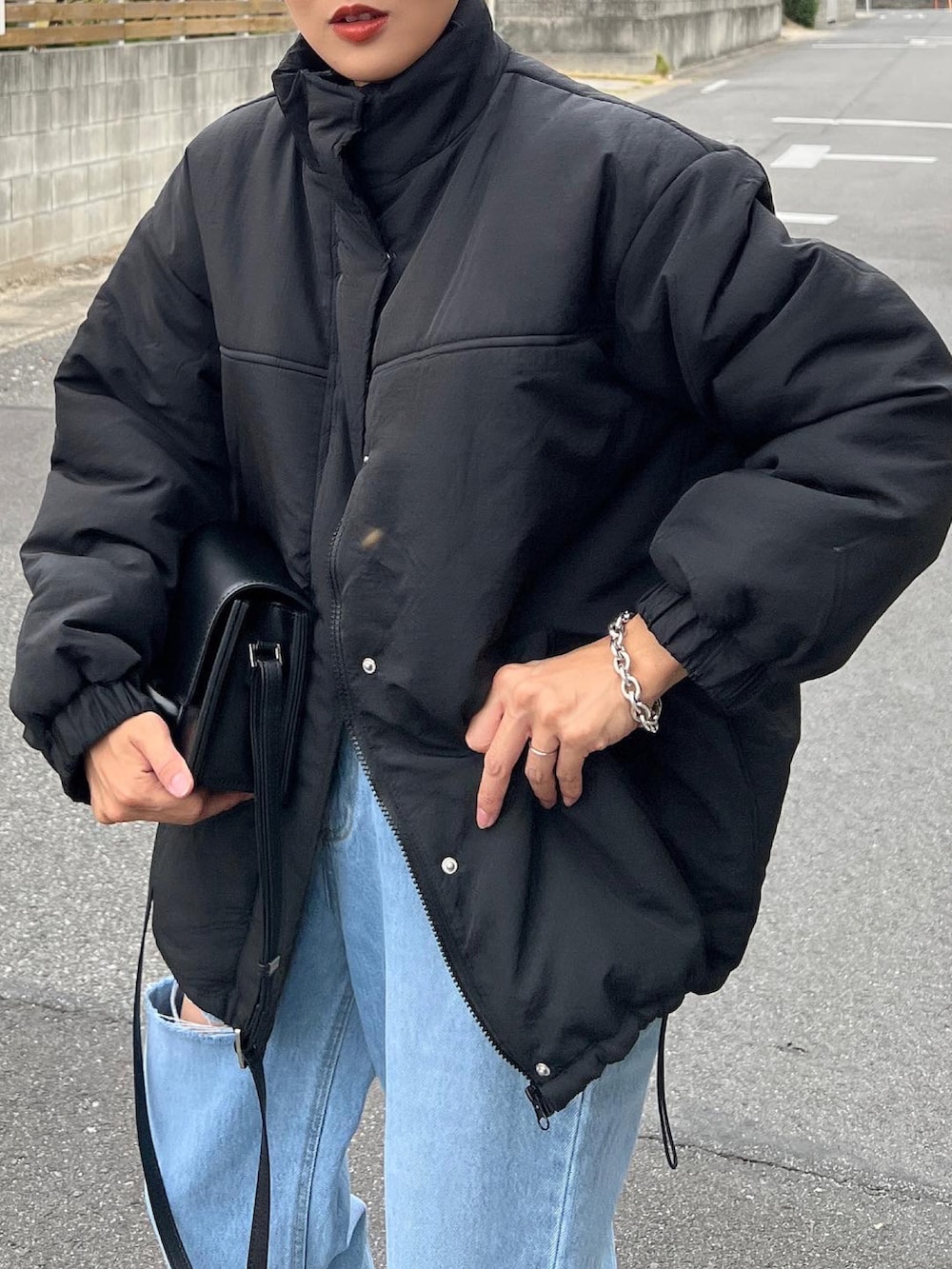 ブラック系のダウンジャケット/コート、ブラック系のショルダーバッグ、ブラック系のローファーを着用したレディースの秋コーディネートの5枚目の写真