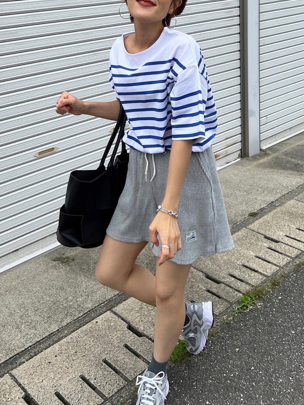 ブルー系のTシャツ/カットソー、グレー系のスニーカーを着用したレディースの春コーディネートの3枚目の写真