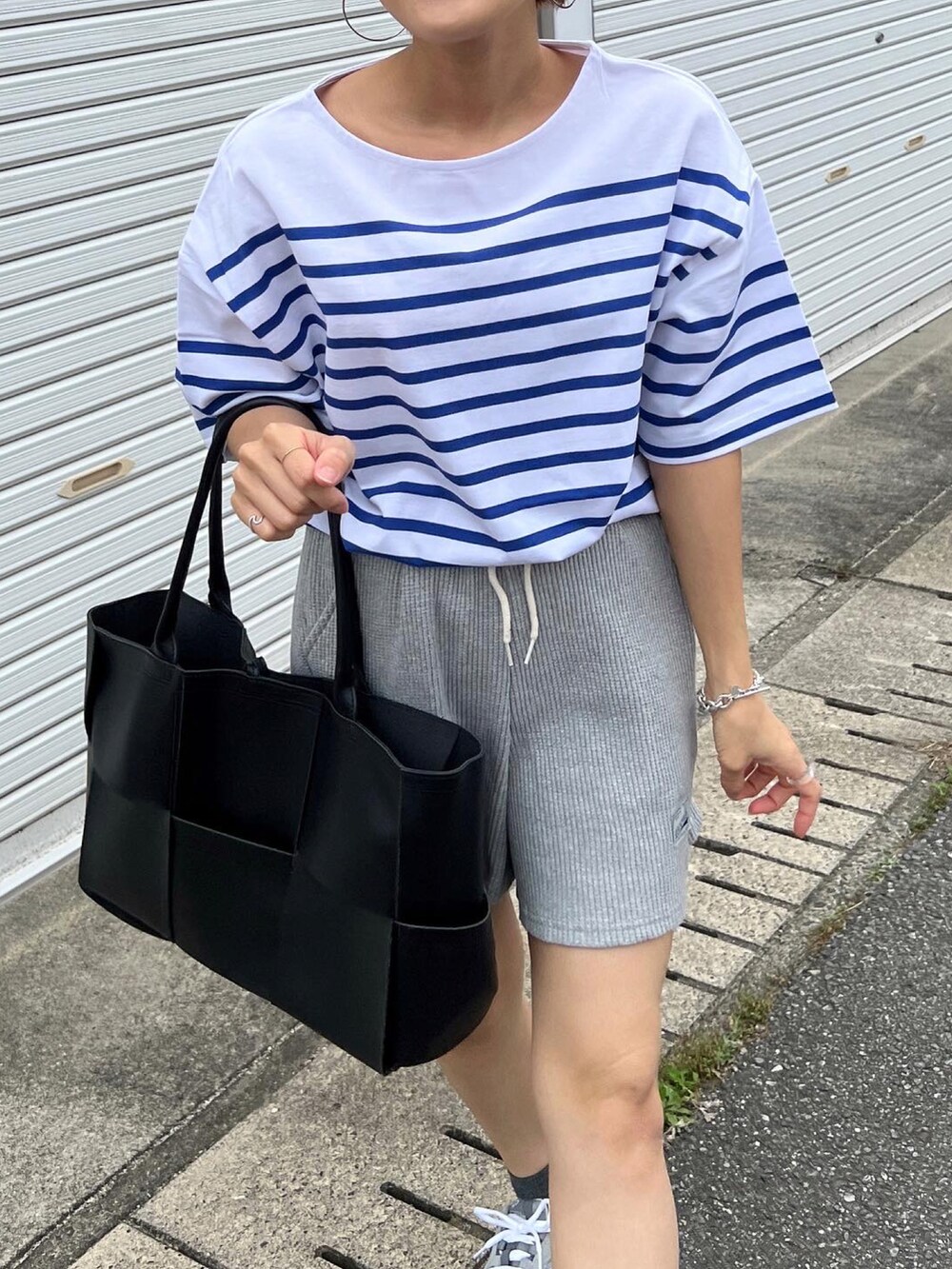 ブルー系のTシャツ/カットソー、グレー系のスニーカーを着用したレディースの春コーディネートの4枚目の写真